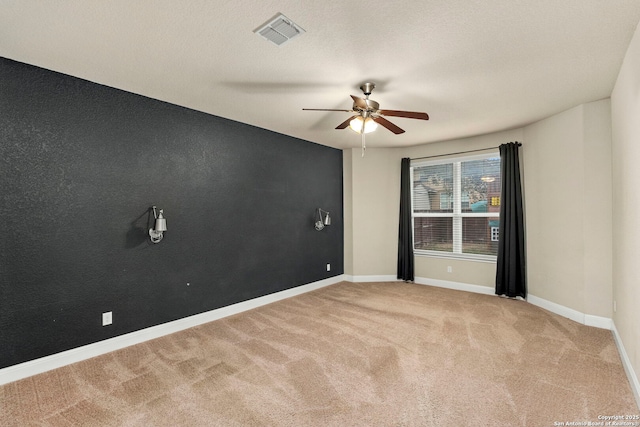 empty room featuring carpet flooring, ceiling fan, and a textured ceiling