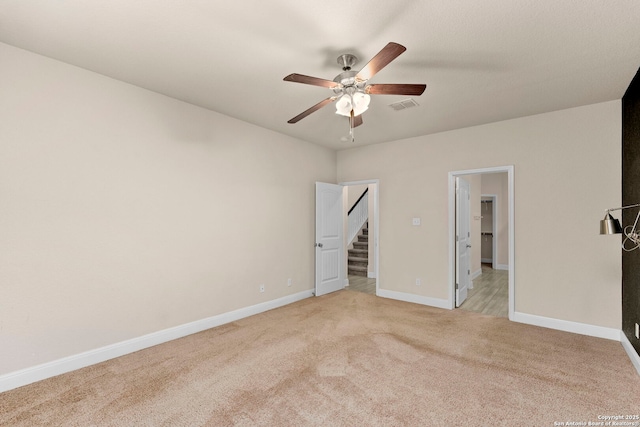 carpeted spare room featuring ceiling fan