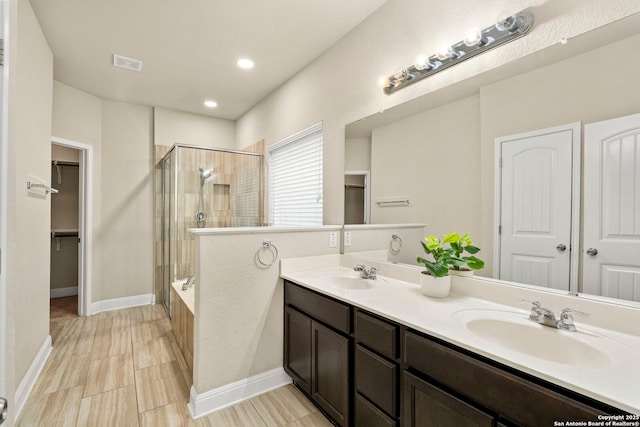 bathroom featuring vanity and independent shower and bath