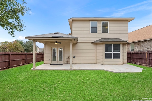 rear view of house featuring ceiling fan, a patio area, and a lawn