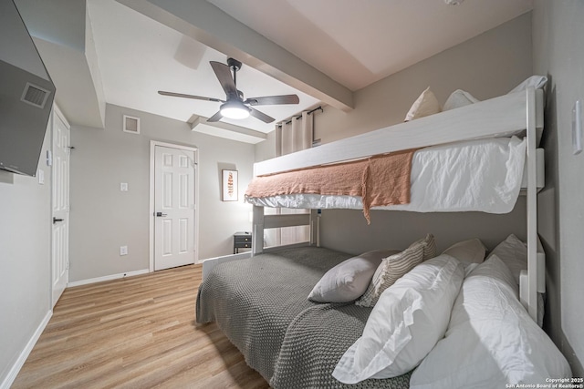 bedroom featuring beam ceiling, light wood-type flooring, and ceiling fan