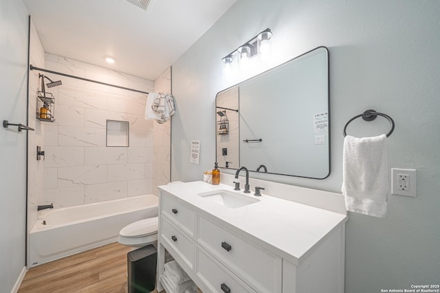 full bathroom featuring wood-type flooring, vanity, toilet, and tiled shower / bath