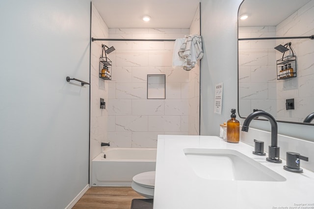 full bathroom featuring vanity, tiled shower / bath, wood-type flooring, and toilet