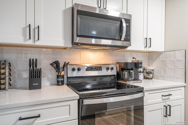 kitchen with light stone counters, white cabinetry, appliances with stainless steel finishes, and tasteful backsplash