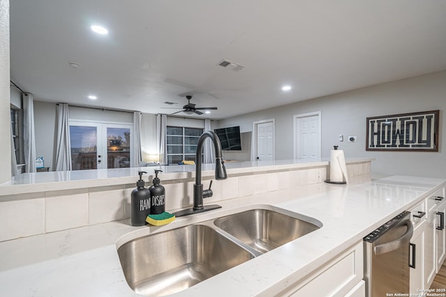 kitchen featuring french doors, light stone counters, ceiling fan, sink, and white cabinetry