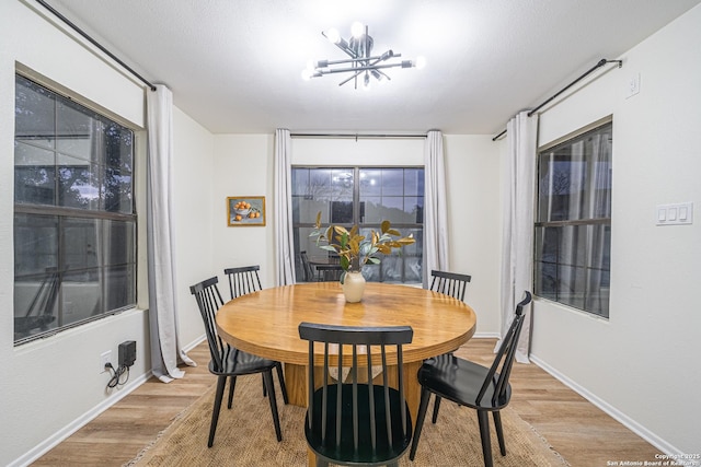 dining space featuring light hardwood / wood-style flooring and a notable chandelier