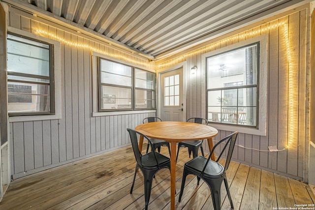 dining area featuring wooden walls and light hardwood / wood-style flooring