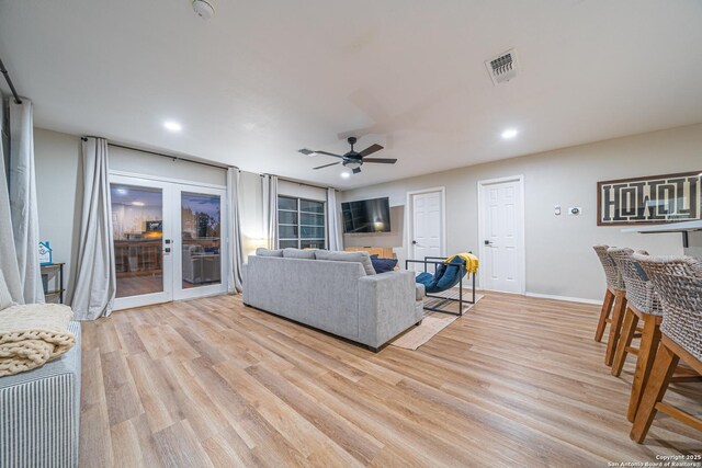 living room featuring french doors, light hardwood / wood-style flooring, and ceiling fan