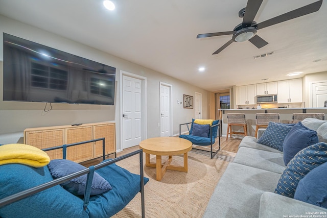 living room with light wood-type flooring and ceiling fan