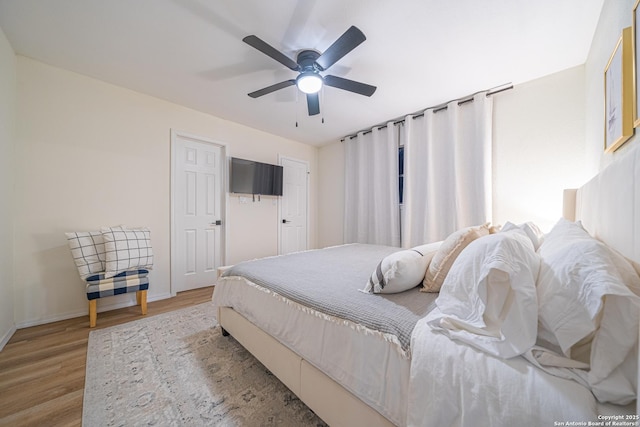 bedroom with ceiling fan and light hardwood / wood-style flooring