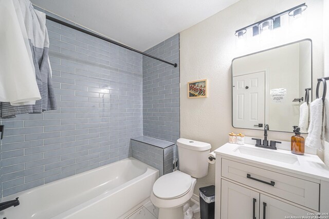 full bathroom featuring tiled shower / bath, vanity, and toilet