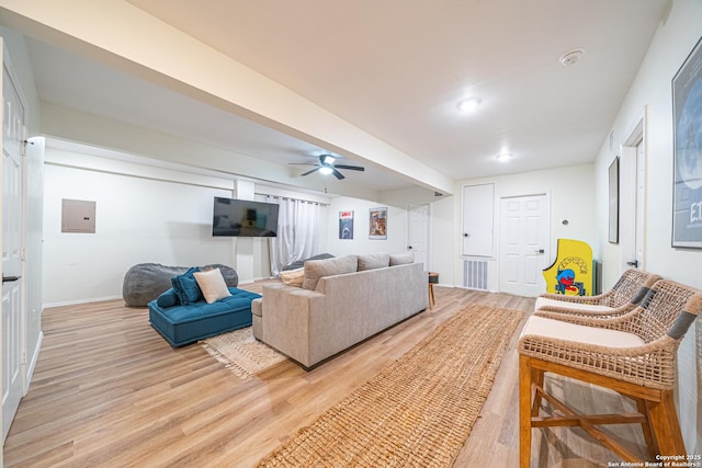 living room with ceiling fan, light hardwood / wood-style floors, and electric panel