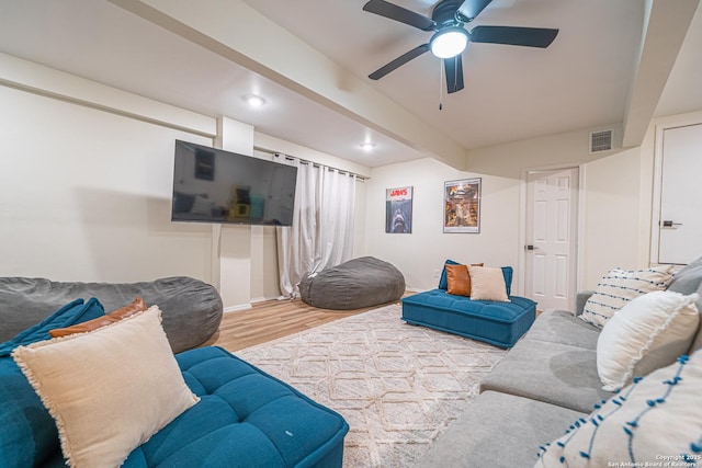 living room with hardwood / wood-style floors, ceiling fan, and beam ceiling