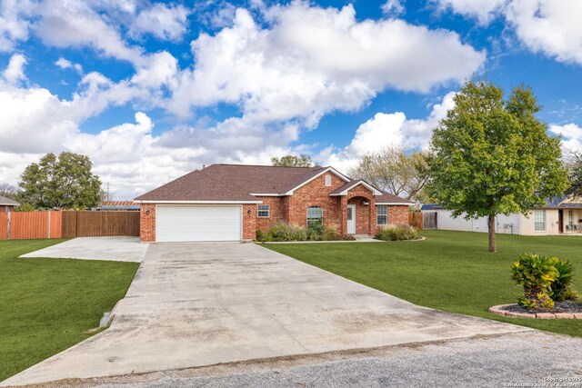 ranch-style house featuring a garage and a front lawn