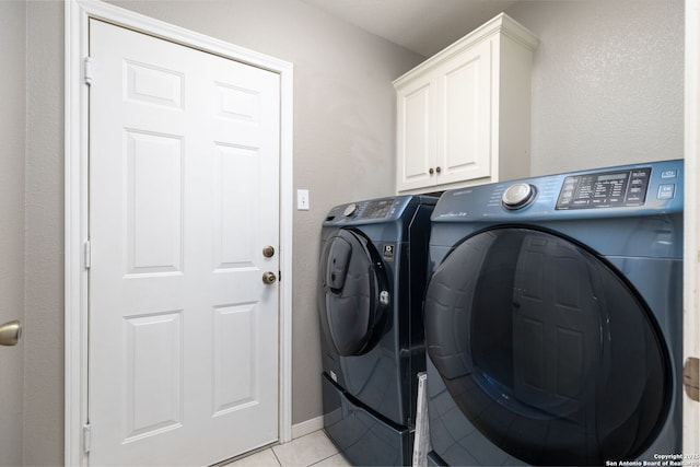 laundry room with light tile patterned floors, cabinets, and independent washer and dryer