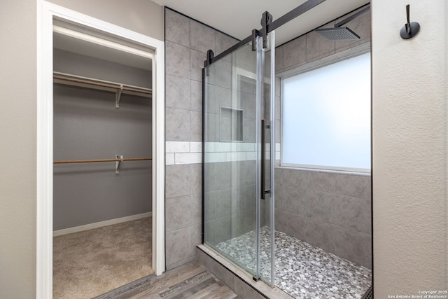 bathroom with wood-type flooring and an enclosed shower