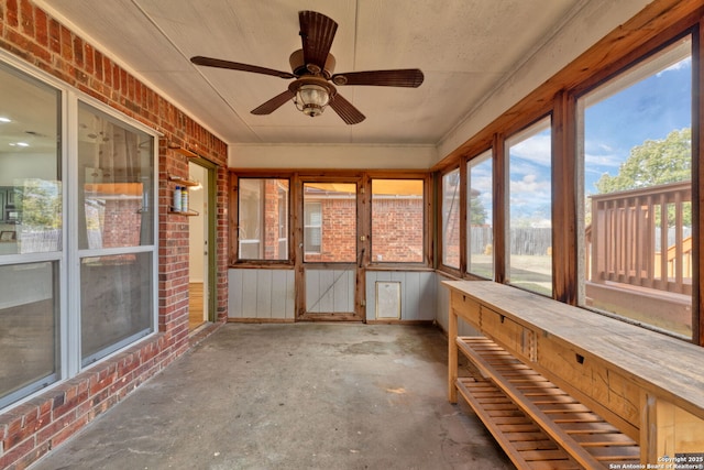 unfurnished sunroom with ceiling fan