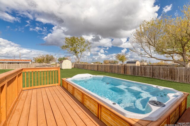 wooden deck with a storage unit and a lawn