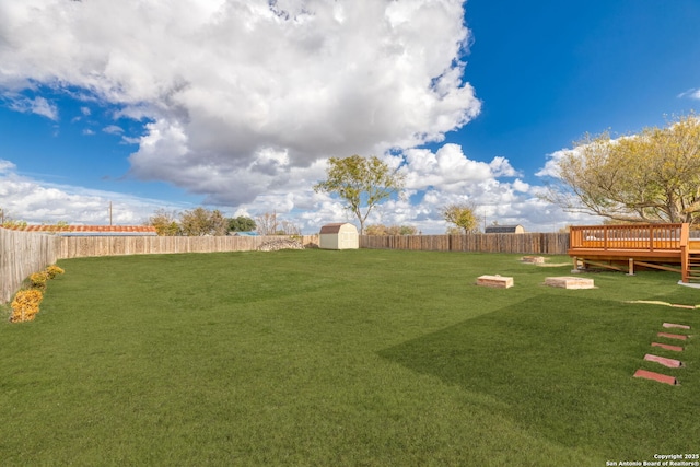 view of yard with a storage shed and a wooden deck