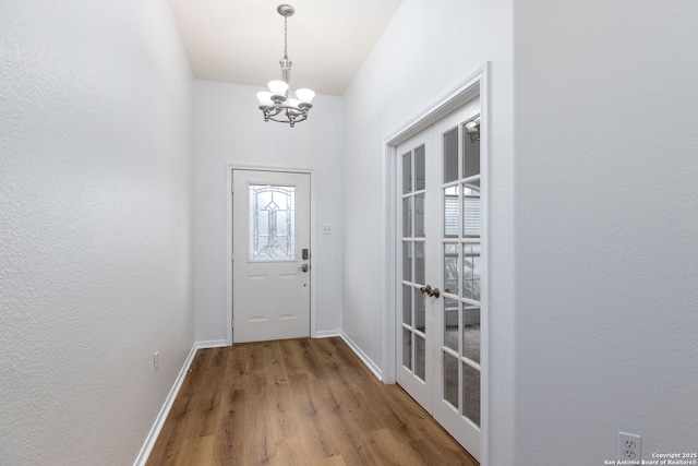 doorway featuring wood-type flooring and an inviting chandelier