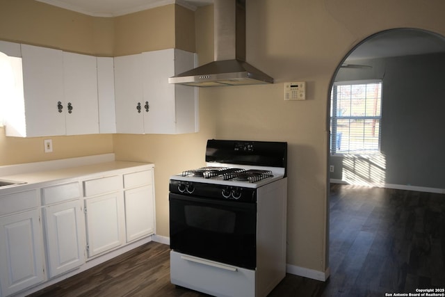 kitchen featuring dark hardwood / wood-style flooring, white cabinetry, white gas range, and wall chimney exhaust hood