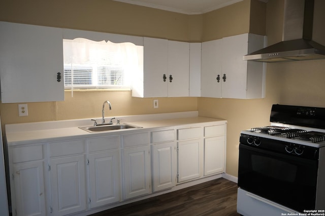 kitchen featuring gas range gas stove, wall chimney exhaust hood, sink, dark hardwood / wood-style floors, and white cabinetry