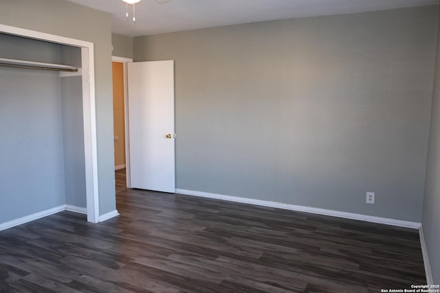 unfurnished bedroom with a closet and dark wood-type flooring