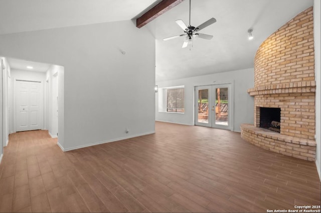 unfurnished living room with a fireplace, french doors, vaulted ceiling with beams, and wood-type flooring