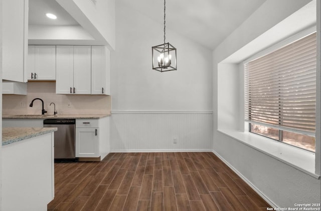 kitchen with stainless steel dishwasher, sink, a chandelier, white cabinetry, and hanging light fixtures