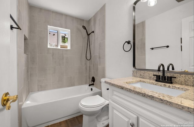 full bathroom with vanity, hardwood / wood-style flooring, toilet, and tiled shower / bath