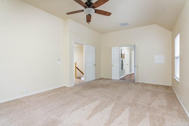 carpeted spare room with vaulted ceiling, ceiling fan, and a healthy amount of sunlight