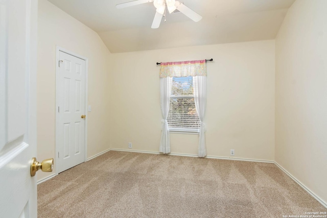 carpeted spare room featuring ceiling fan and vaulted ceiling