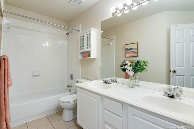 full bathroom with tile patterned flooring, tiled shower / bath combo, toilet, and vanity