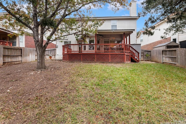 rear view of house featuring a sunroom, a yard, and a deck