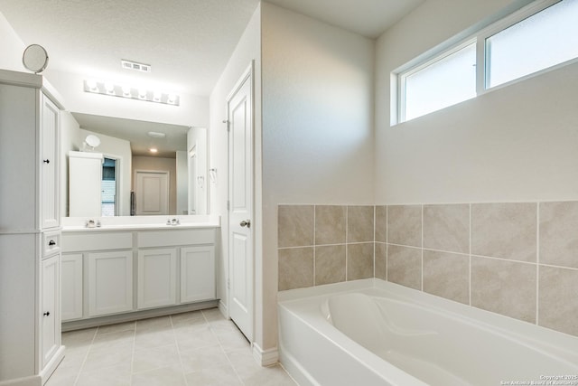 bathroom featuring tile patterned flooring, a washtub, and vanity