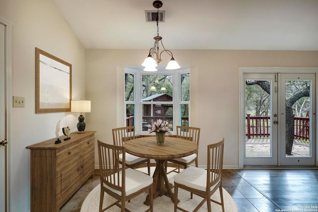 dining room featuring vaulted ceiling, a wealth of natural light, and an inviting chandelier