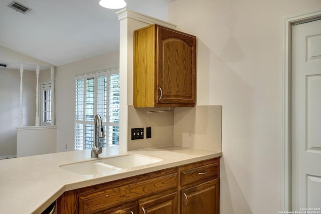 kitchen with tasteful backsplash, lofted ceiling, and sink