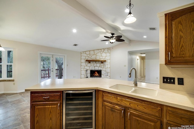 kitchen with french doors, lofted ceiling with beams, sink, decorative light fixtures, and beverage cooler