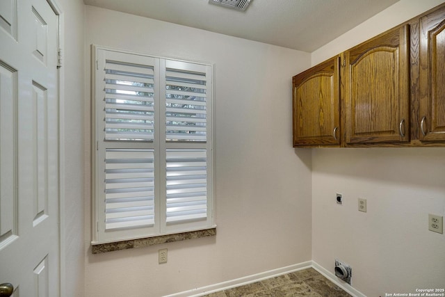 clothes washing area featuring cabinets and electric dryer hookup