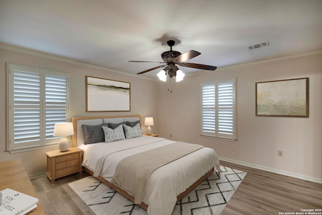 bedroom featuring light wood-type flooring, ceiling fan, and crown molding