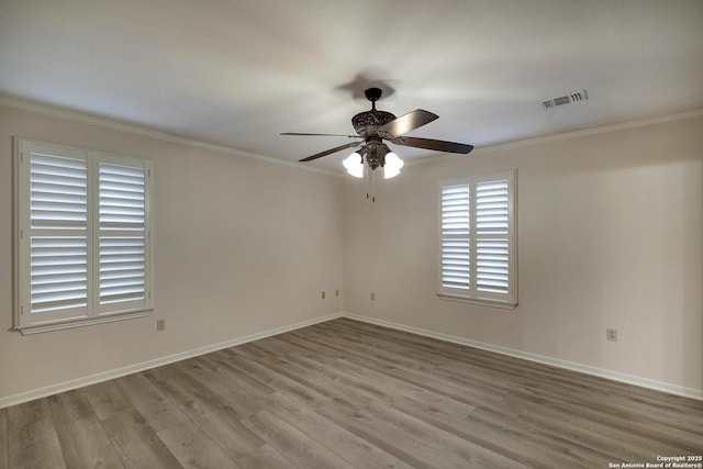 spare room featuring ceiling fan, ornamental molding, and light wood-type flooring