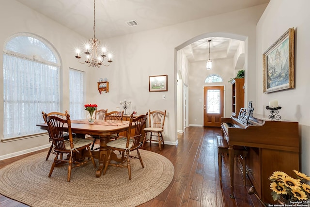 dining area featuring dark hardwood / wood-style floors and an inviting chandelier