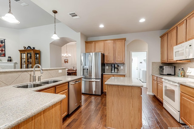 kitchen featuring pendant lighting, stainless steel appliances, a center island, and sink