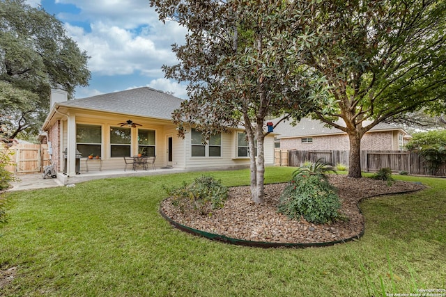 rear view of property featuring ceiling fan, a yard, and a patio