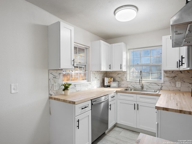 kitchen with sink, wood counters, stainless steel dishwasher, decorative backsplash, and white cabinets