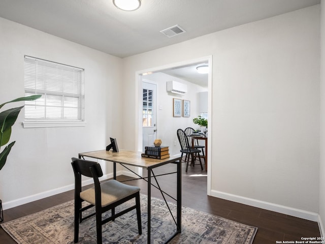 office space with a wall mounted AC and dark wood-type flooring