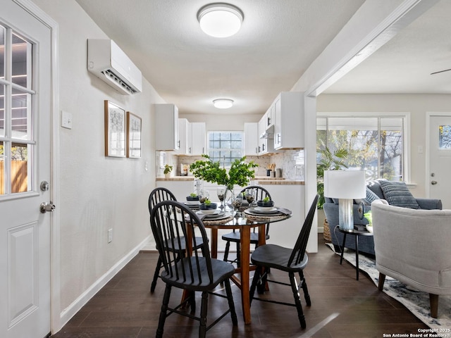 dining area with dark hardwood / wood-style flooring and an AC wall unit