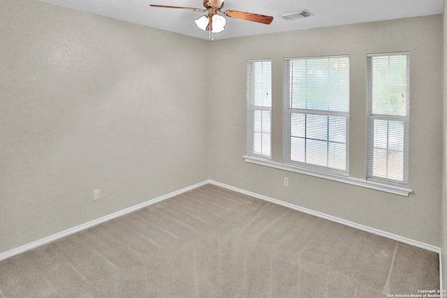 carpeted spare room featuring ceiling fan and a healthy amount of sunlight