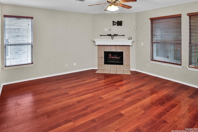 unfurnished living room featuring a fireplace, wood-type flooring, and ceiling fan