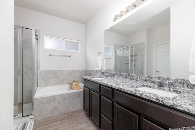 bathroom featuring separate shower and tub and vanity